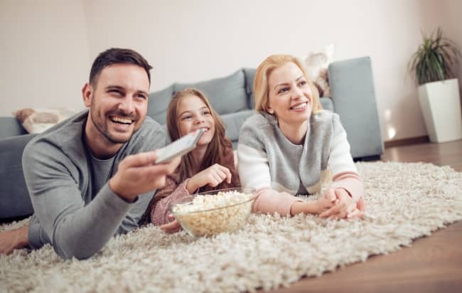 Family watching a movie togther at home.