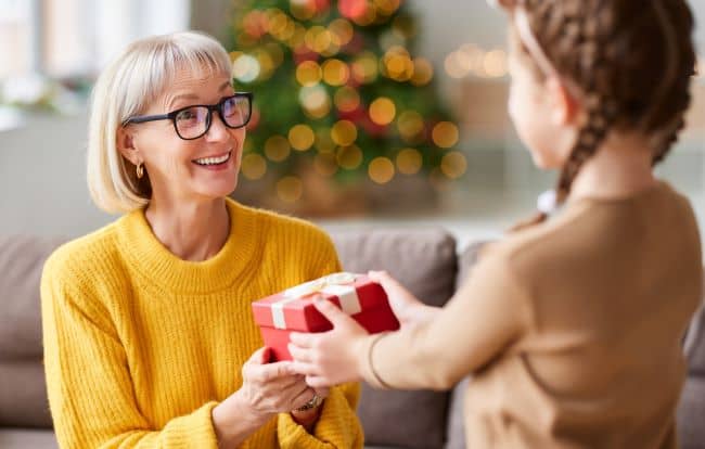 Little girl giving gift to an elderly neighbor.